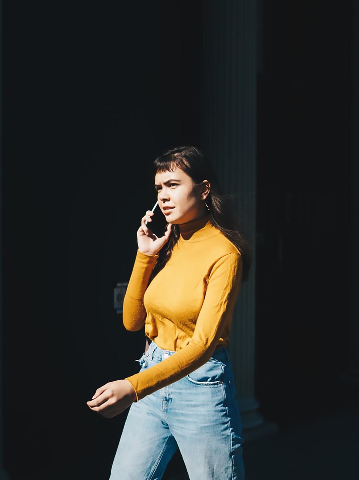 kävelevä nainen puhuu puhelimessa